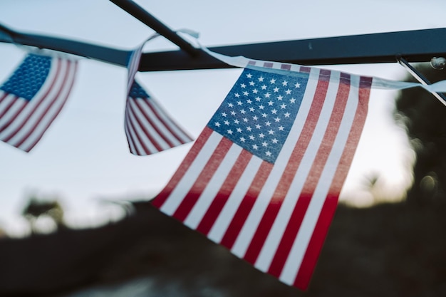 Nahaufnahme von kleinen amerikanischen Flaggen, die während des Sonnenuntergangs hängen