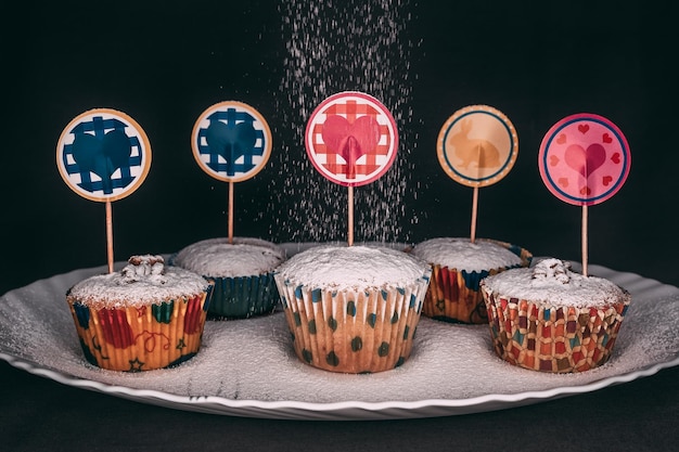 Nahaufnahme von kleinen Kuchen mit schwarzem Hintergrund der Valentinstagdekorationen