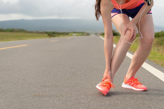 Nahaufnahme von Knöchelverletzungen bei Sportlerinnen beim Laufen auf der Straße Fitness und stoppen Sie die schmerzhafte Handhaltung mit schönem Hintergrund.