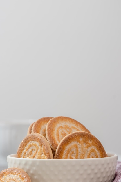 Foto nahaufnahme von knusprigen keksen in einer weißen schüssel auf hellem hintergrund, kopierraum, maria-kekse
