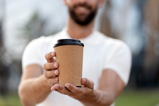 Nahaufnahme von lächelnden Mannhänden, die eine Tasse Kaffee halten, selektiver Fokus Kaffeepause, Getränk zum Mitnehmen