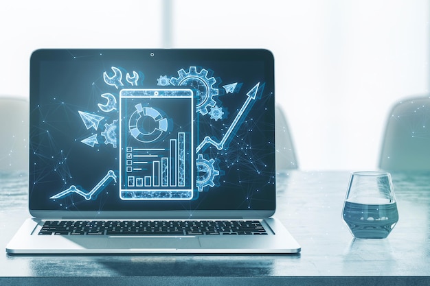 Nahaufnahme von Laptop und Glas auf dem Schreibtisch mit kreativer polygonaler Schnittstelle mit Zahnrädern und Geschäftsdiagramm auf blauem Hintergrund Projektmanagement-Tool und Online-Finanzsystem-Konzept 3D-Rendering