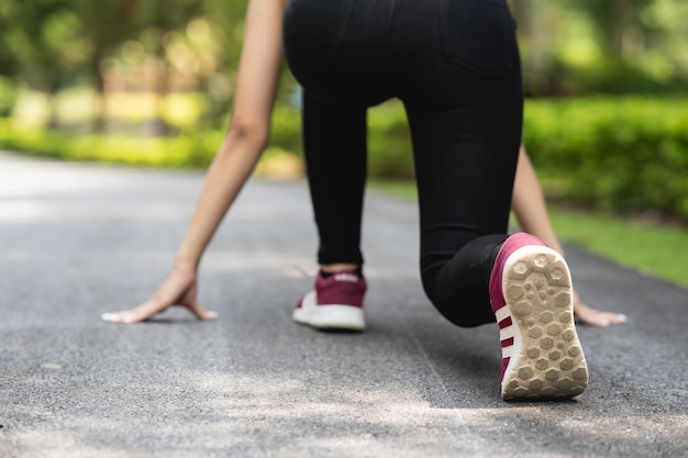 Nahaufnahme von Laufschuhen oder Füßen Sportlerin Läufer passen Körper vor Beginn des Laufens oder Joggens im Garten mehr Baum und saubere Luft trainieren im Park Sport gesundes Laufkonzept