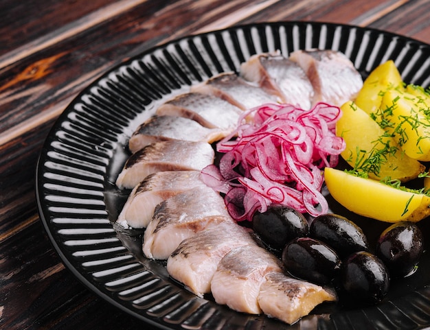 Nahaufnahme von lecker mariniertem Hering mit Kartoffeln und Zwiebeln in der Platte