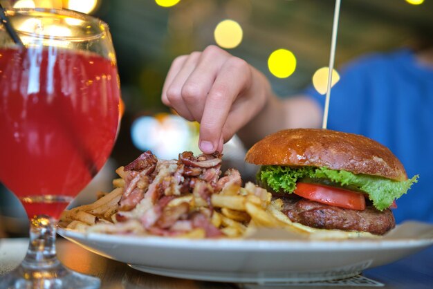 Nahaufnahme von leckeren Burger und Pommes Frites mit Fleisch auf dem Teller im Restaurant.