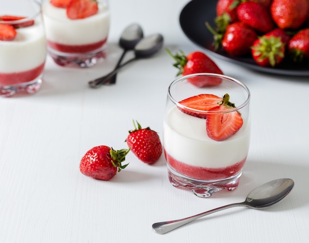 Nahaufnahme von leckeren Erdbeer Panna Cotta auf weißem Tisch zum Frühstück?