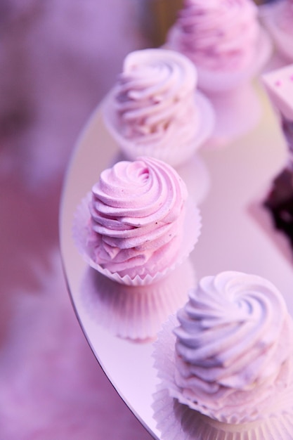 Nahaufnahme von leuchtend rosa Cupcakes auf einem verspiegelten Ständer