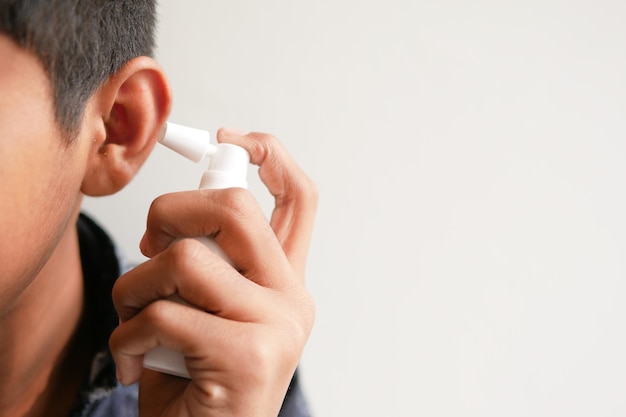 Nahaufnahme von Männern, die Ohrenschmalz mit Spray entfernen