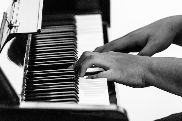 Nahaufnahme von männlichen Händen, die Klavier spielen