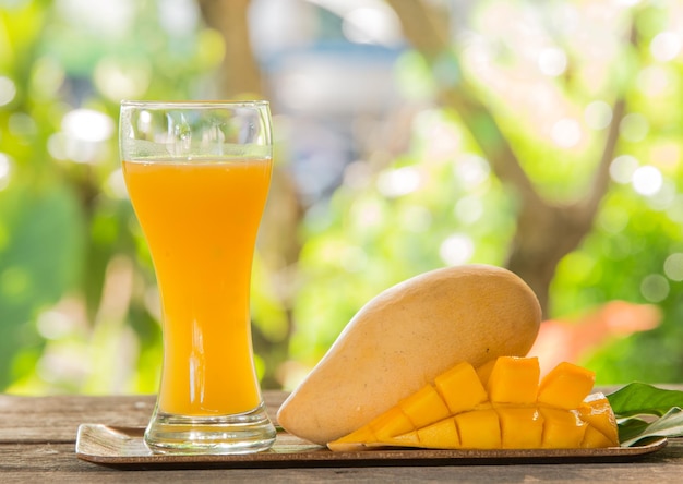 Foto nahaufnahme von mango mit saft im korb auf dem tisch