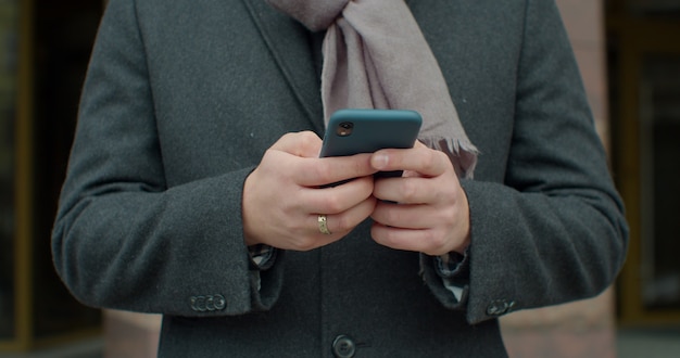 Nahaufnahme von Mans Hands. Junger Geschäftsmann, der sein Smartphone benutzt.