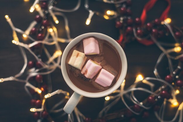 Nahaufnahme von Marshmallows in Kaffee auf einem mit Beleuchtung umgebenen Tisch