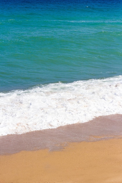 Nahaufnahme von Meereswellen am Sandstrand im Sommer?