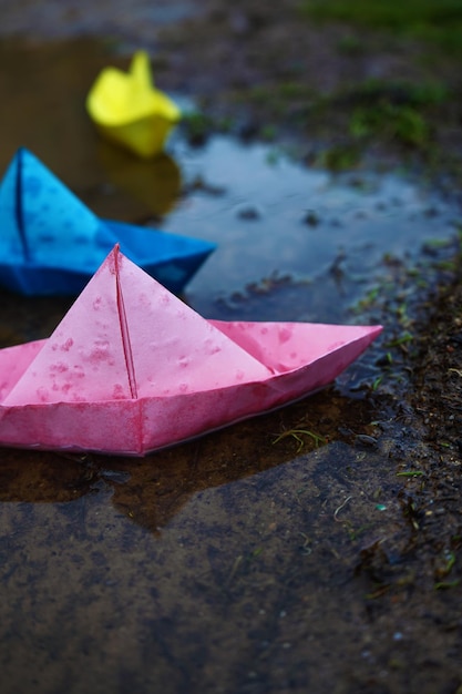 Nahaufnahme von mehrfarbigen Papierbooten, die auf dem Wasser schwimmen