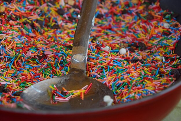 Nahaufnahme von mehrfarbigen Sprinkles mit Löffel in der Schüssel