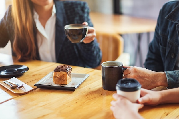 Nahaufnahme von Menschen genossen es, im Café zusammen zu reden, zu essen und Kaffee zu trinken?