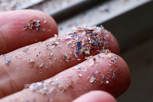 Nahaufnahme von Mikroplastik auf der Hand der Menschen. Konzept der Wasserverschmutzung und der globalen Erwärmung. Idee zum Klimawandel.