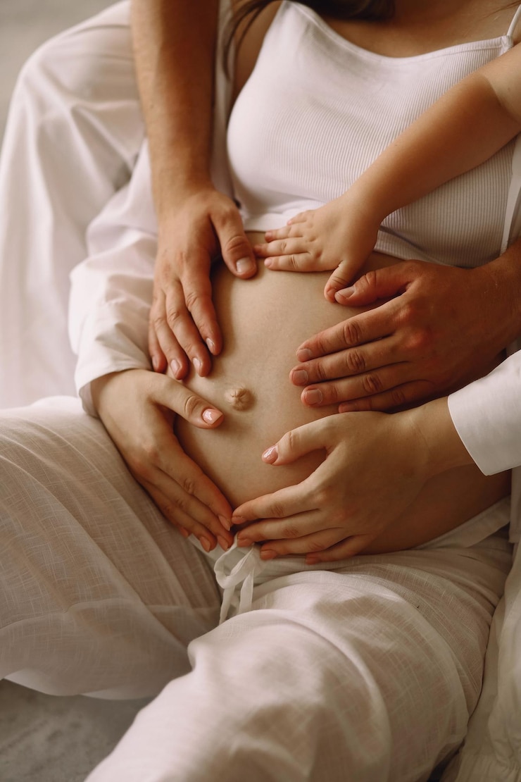 Foto nahaufnahme von mitgliedern einer glücklichen familie, die ihre hände auf den schwangeren bauch halten und ein baby erwarten