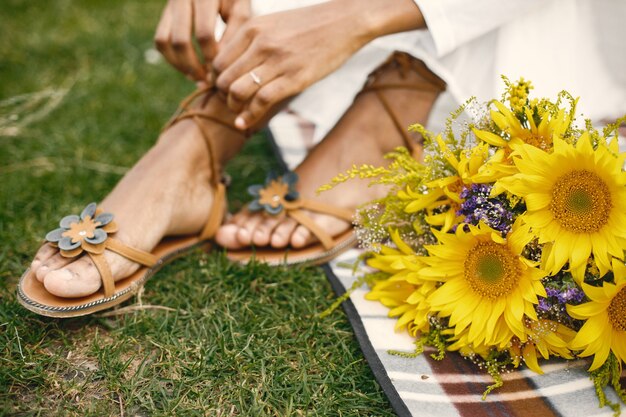 Nahaufnahme von muslimischen Frauenhänden, die ihre offenen Sommersandalenschuhe binden