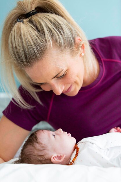 Nahaufnahme von Mutter, die auf die süße Tochter schaut, die auf dem Bett liegt