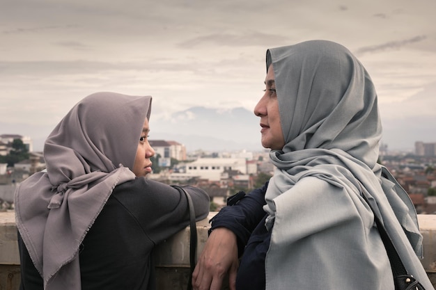 Nahaufnahme von Mutter und Tochter, die in der Stadt gegen den Himmel stehen