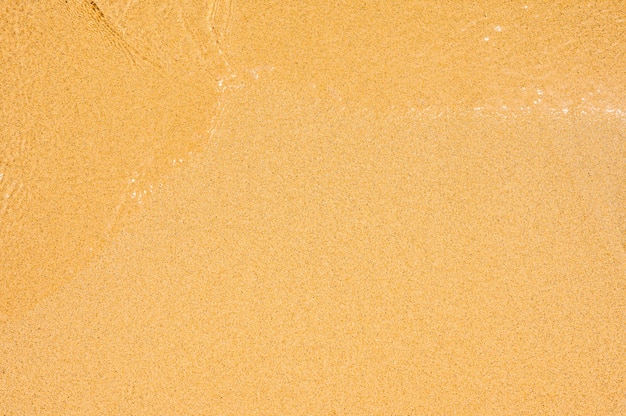 Foto nahaufnahme von nassem sand texturmuster am strand. klarer sandstrand. strandsand perfekte glatte textur