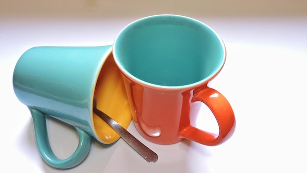 Nahaufnahme von orangefarbenen Kaffeetassen auf weißem Hintergrund