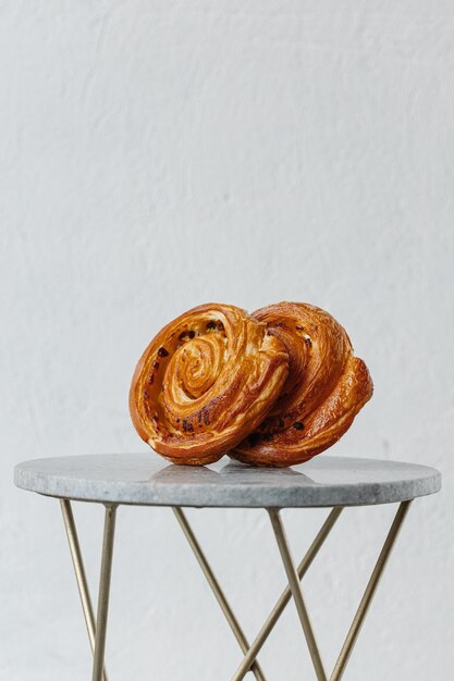 Nahaufnahme von Pain aux Rosinen oder niederländischer Koffiebroodje-Übersetzungskaffeerolle in einem weißen Innenraum