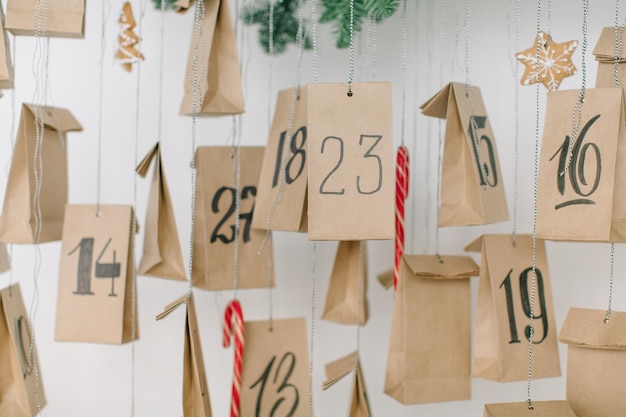 Foto nahaufnahme von papiertüten mit zahlen, die zu weihnachten zu hause hängen