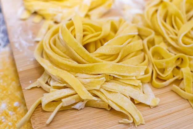 Nahaufnahme von Pasta und Händen, die hausgemachte italienische Pasta machen