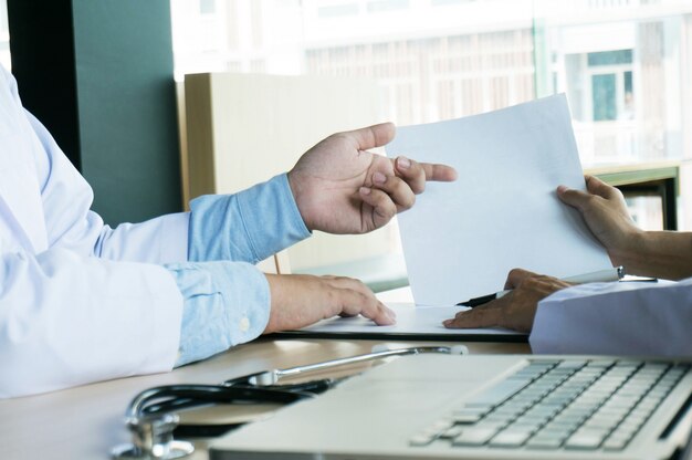 Nahaufnahme von Patienten und Arzt Notizen oder professionelle Arzt in weißen Uniform Kleid Mantel Interview