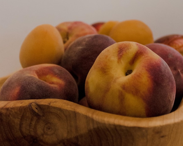 Nahaufnahme von Pfirsichfrüchten auf einer Holzschüssel