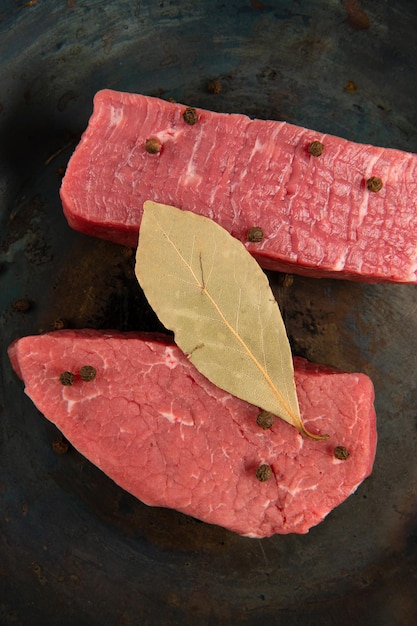 Nahaufnahme von rohem Fleisch, Pfeffer und Lorbeerblatt