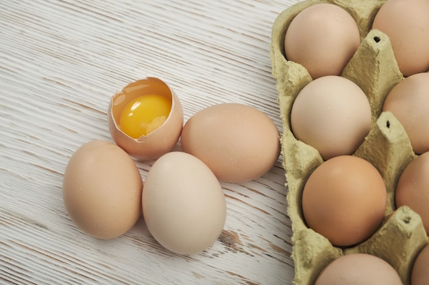 Nahaufnahme von rohen Hühnereiern im Eierkarton auf Holzhintergrund. Rohe Hühnereier in Eierkarton Bio-Lebensmittel für eine gute Gesundheit mit hohem Proteingehalt.