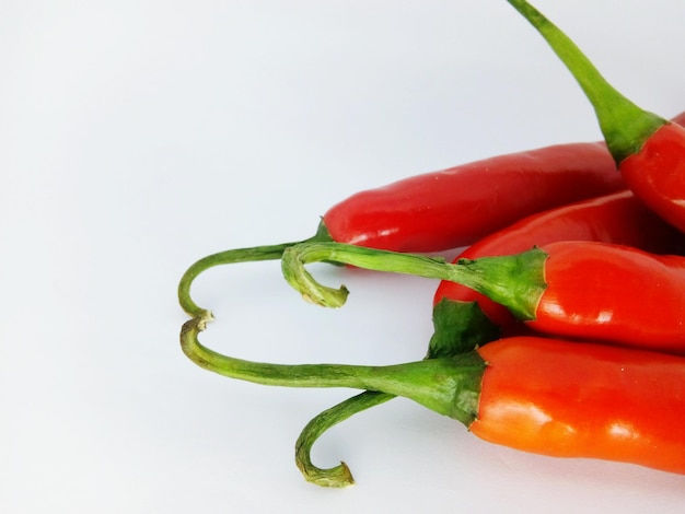 Nahaufnahme von roten Chilischoten auf weißem Hintergrund