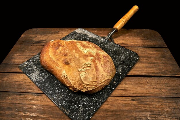 Foto nahaufnahme von rustikalem brot auf dem holztisch