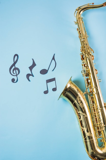Foto nahaufnahme von saxophones mit musikalischen anmerkungen über blauen hintergrund