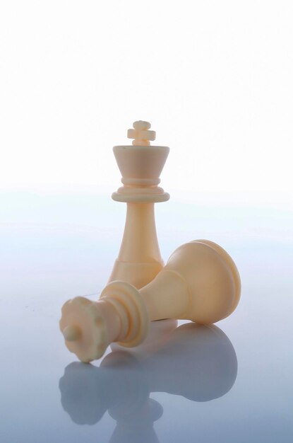 Nahaufnahme von Schachfiguren vor weißem Hintergrund.