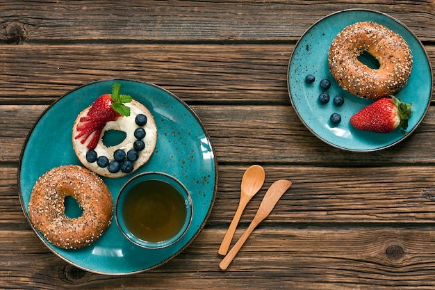 Nahaufnahme von Schaumgummiringen mit frischen Beeren und Tasse Tee.