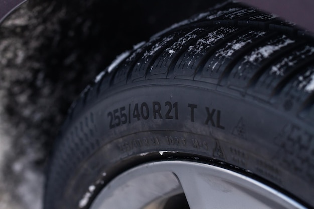 Nahaufnahme von schneebedeckten Reifen mit Reifenbreite, Höhe und Raddurchmesserbezeichnung Etiketten für Winterreifengrößentypen