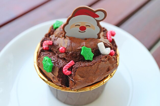 Nahaufnahme von Schokoladen-Cupcake mit Santa Choco und Weihnachtsstreuseln