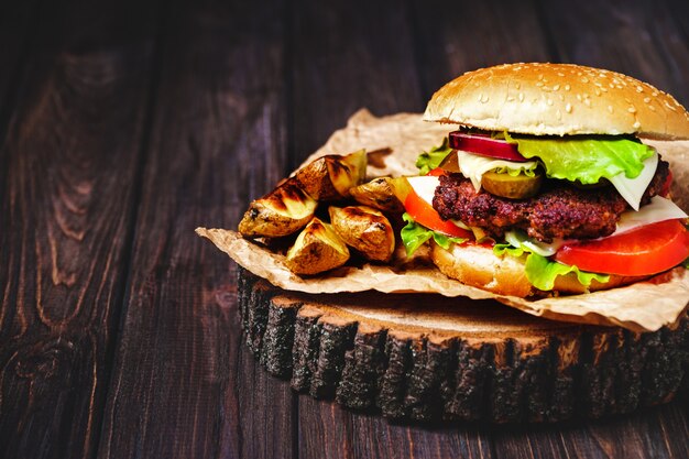 Nahaufnahme von selbst gemachten Rindfleischburgern mit Kopfsalat und Majonäse diente auf wenigem hölzernem Schneidebrett.