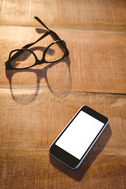 Nahaufnahme von Smartphone und Brille