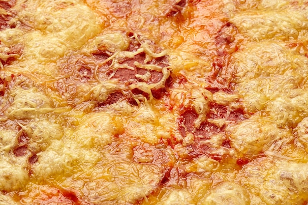 Nahaufnahme von Sojawurstscheiben unter geschmolzenem vegetarischem Mozzarella auf veganer Pizza