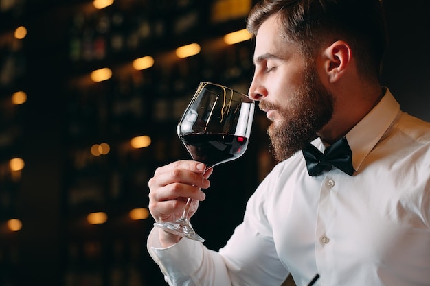 Nahaufnahme von Sommelier-Mann, der Wein im Glas schnüffelt