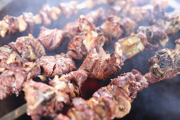 Nahaufnahme von Spießen mit saftigem Fleisch im Rauch