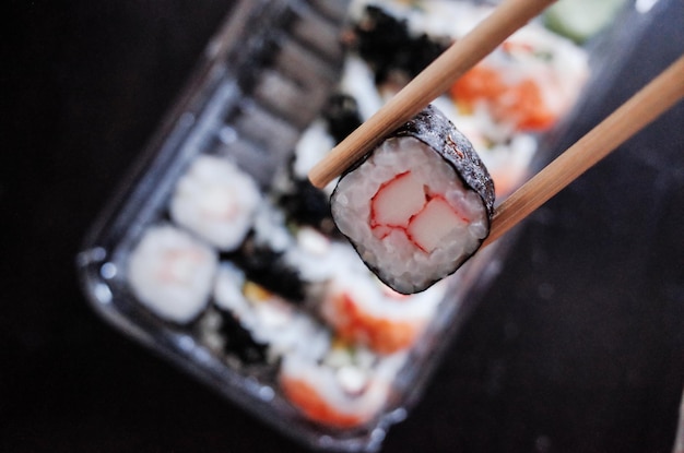 Nahaufnahme von Stäbchen mit Sushi