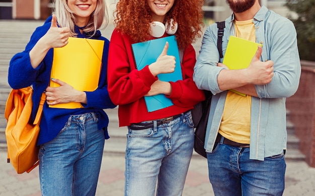 Nahaufnahme von Studentenfreunden, die Daumen hoch zeigen