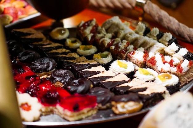 Nahaufnahme von Tablett mit leckeren Kuchen Törtchen in Folge. Frische bunte süße Beerendesserts, wunderschön dekoriert