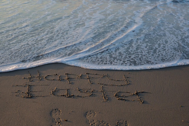 Nahaufnahme von Text auf Sand am Strand